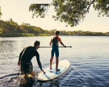 Father son paddle boarding on river