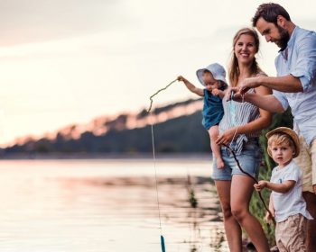 Tributary family fishing on river shoreline