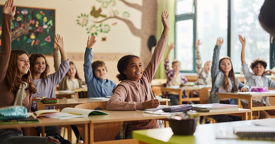 Classroom of students, girl raising hand