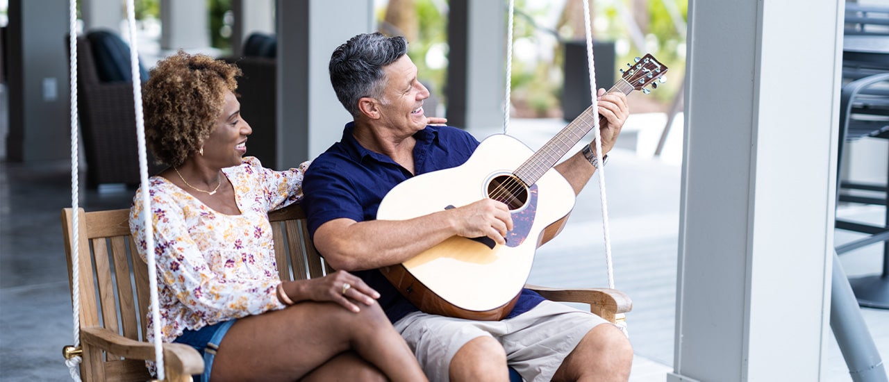 Couple on swing with guitar at Tributary